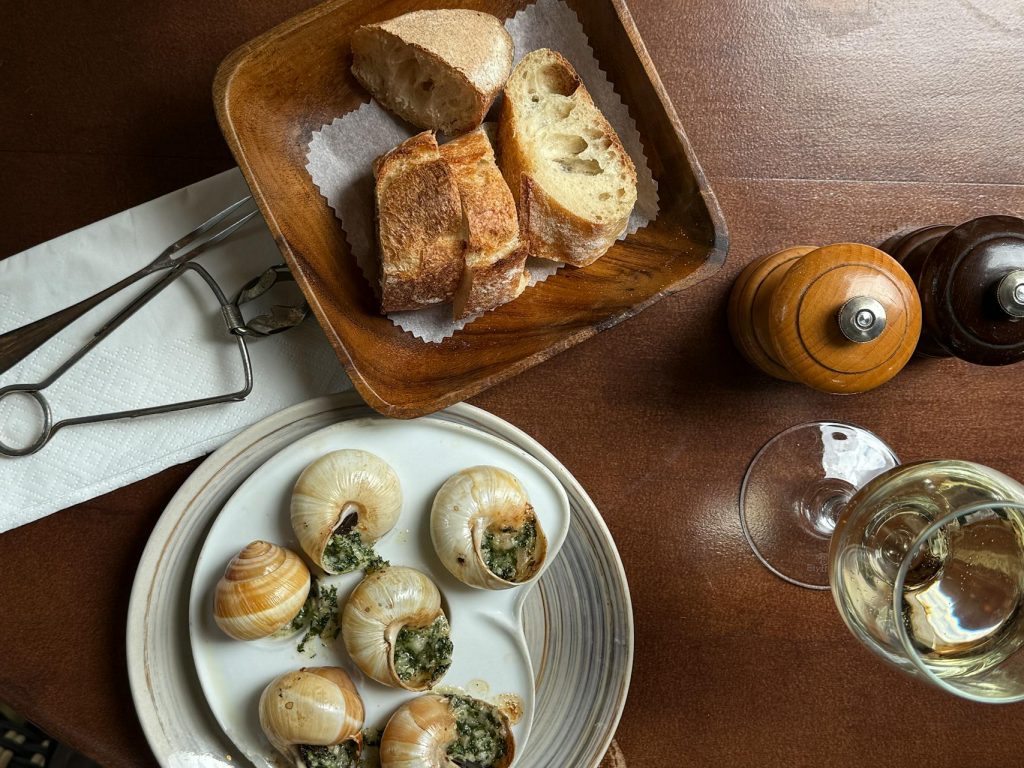 Caracoles Con Pan Y Vino Sobre Una Mesa De Madera
